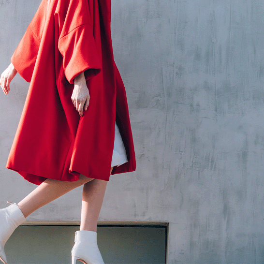 femme-elegante-portant-un-manteau-rouge-doccasion-et-marchant  